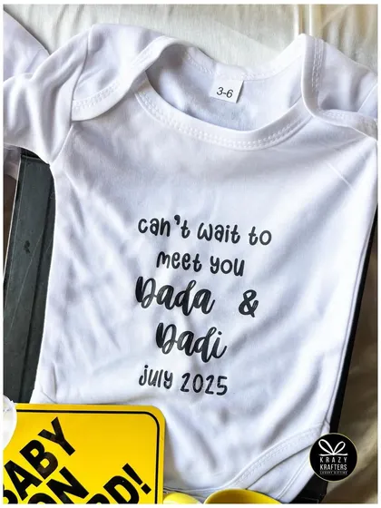 A detailed shot of the custom-printed baby onesie, a central piece in our pregnancy announcement hampers that can be personalized with any family relation.