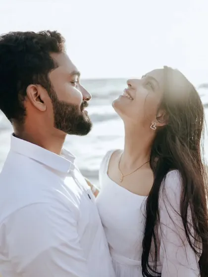 A sun-kissed photo of a couple on the beach, their faces lit up with joy and the warmth of the sun.
