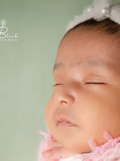 A profile shot that captures the delicate features of this beautiful baby girl. Her closed eyes and soft skin are the picture of newborn innocence.