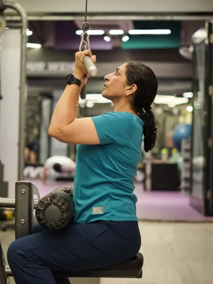 The lat pulldown is a key exercise for developing a wide, strong back. This client is focused on pulling the bar down with proper technique.