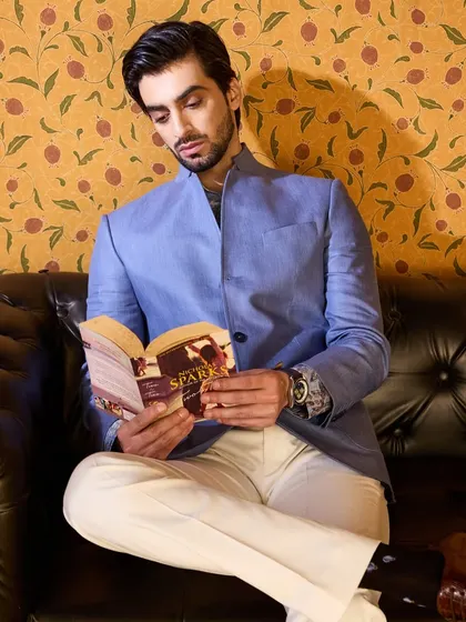 Even in a moment of quiet reading, the handcrafted silhouette of the linen jacket stands out. It's a piece designed for the modern man's lifestyle.