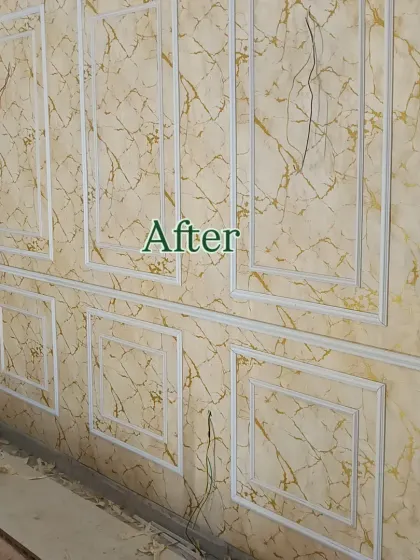 After: This image shows a wall after I've installed a gold marble-effect wallpaper and decorative moulding for an elegant, paneled look.