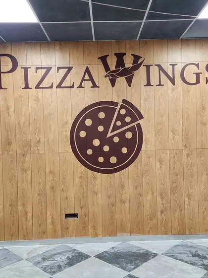 We painted the Pizza Wings logo directly onto a wood-paneled wall, creating a rustic and bold branding statement. Our typography work is clean, sharp, and perfectly scaled to the space.