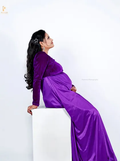 A graceful side pose in the purple maternity gown, perfect for capturing an elegant and artistic pregnancy portrait.