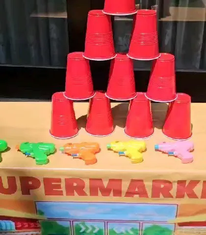 A close-up of the water guns and cup tower for the firefighter training game.