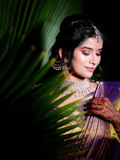 A creative portrait of the bride, using a palm leaf to create interesting shadows and framing.
