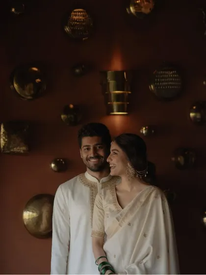 A smiling portrait against a beautifully decorated wall. This pre-wedding photo perfectly balances elegance and happiness, showcasing the couple's style and connection.