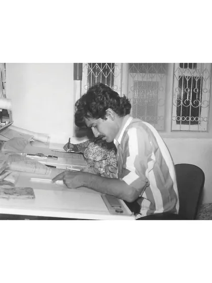 An archival photograph of our principal architect at the drafting board. This image reflects our enduring belief that simplicity is the ultimate sophistication, a principle that has guided our practice from the very beginning.