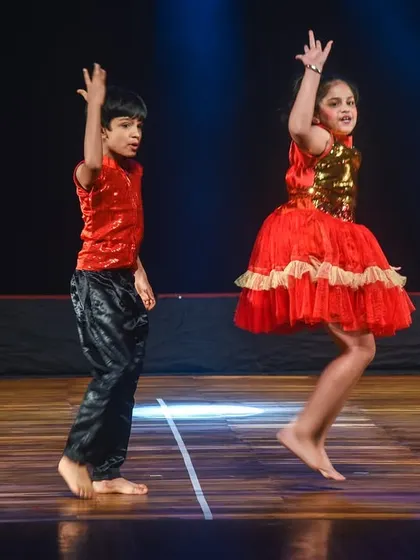 A boy and girl jumping in sync, capturing the dynamic and athletic side of Bollywood dance.