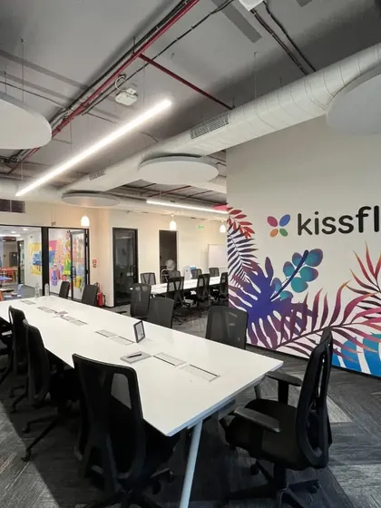The Kissflow logo and a tropical mural are prominently featured in the main workspace. This integration of branding and biophilic art creates a strong sense of place and identity for the employees.