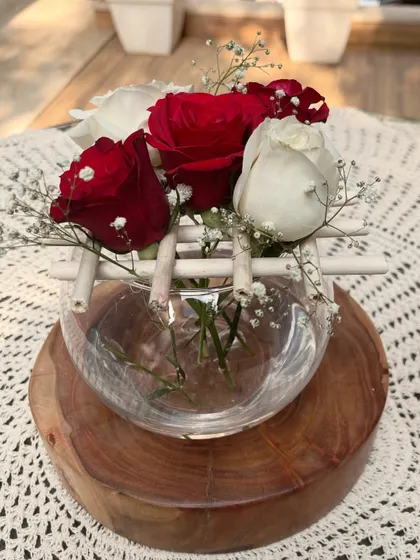 A simple yet elegant Christmas centerpiece created with red and white roses in a glass bowl. This DIY floral arrangement is a perfect way to add a touch of festive spirit and natural beauty to your holiday table.
