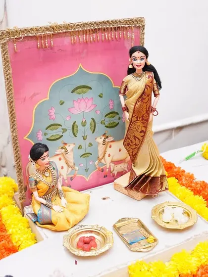 A close-up of a 'dohale jevan' scene, showing a mother doll with her child against a backdrop inspired by Pichwai art. This setup beautifully captures the essence of motherhood.