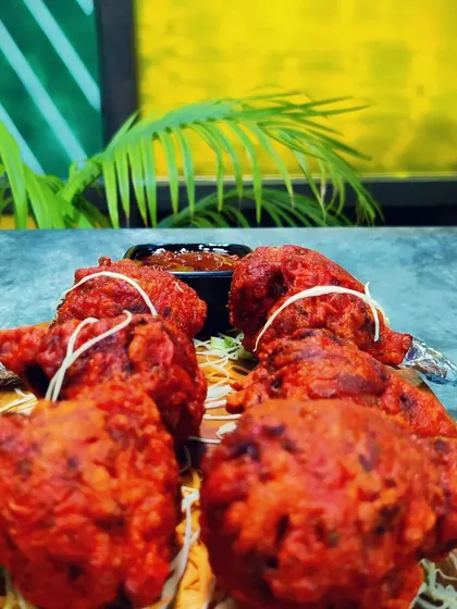 A platter of freshly fried Chicken Lollipops, ready to be served. A perfect party starter or an indulgent snack.