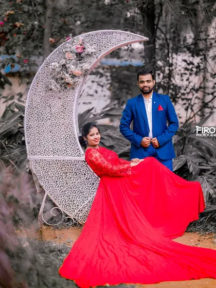 A creative edit using selective color to make the couple pop. The woman's red gown stands out against the monochrome background, drawing all the attention to them as they pose with the moon prop.