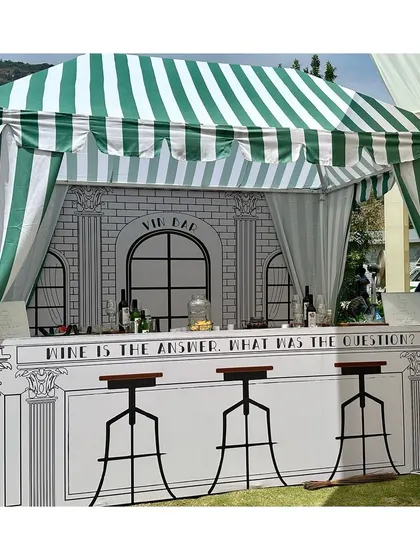 A 'Vin Bar' designed with a green and white striped canopy and a charming illustrated backdrop, adding a touch of Parisian flair to the Haldi event.