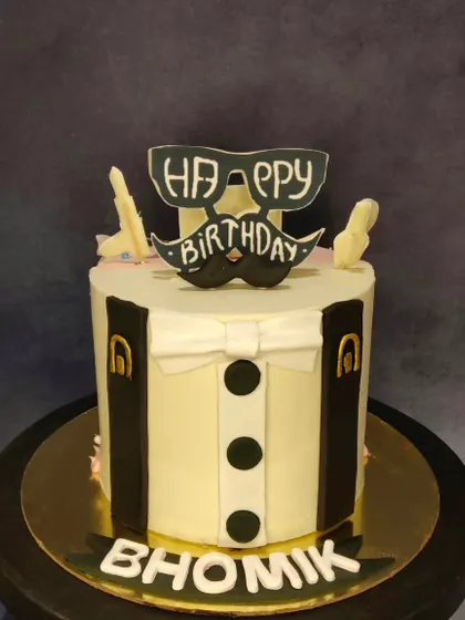 A dapper suit and tie cake, perfect for a gentleman's birthday. The design is clean and sharp, featuring a shirt, bow tie, and suspenders.