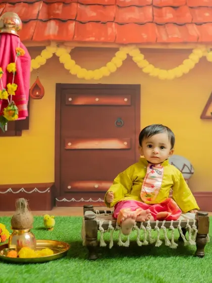 Seated on a miniature charpai, this little one looks adorable. I use age-appropriate props to add variety and charm to the photoshoot.