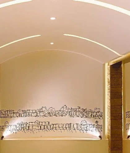 A custom wall mural that captures timeless architecture in a line-art style. This artistic feature, illuminated by spotlights, adds a layer of cultural narrative and visual interest to the interior space.