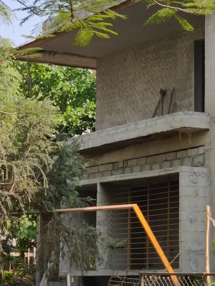 A close-up of the villa's structure, showing the texture of the concrete blocks and the cantilevered slabs.