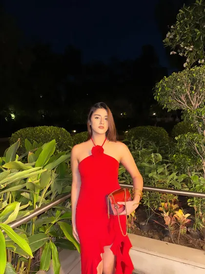 A full-length shot of the red dress, holding a matching red clutch. The perfect prom or date night look.