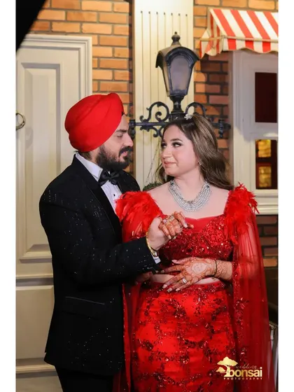 The couple sharing a dance at their engagement party, looking stunning in red and black.
