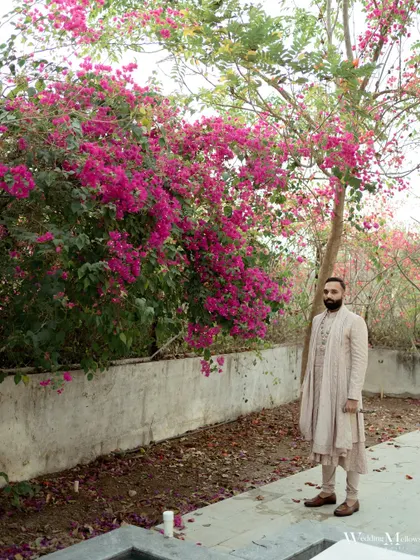 A stunning portrait of the groom, Dhairya, against a wall of vibrant bougainvillea. We love using natural elements to create beautiful, colorful backdrops.