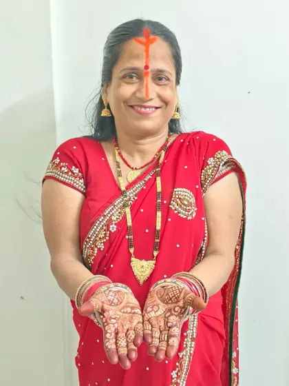 Maa's smile says it all. Her hands are beautifully decorated with traditional mehndi for the Chhath Puja rituals.