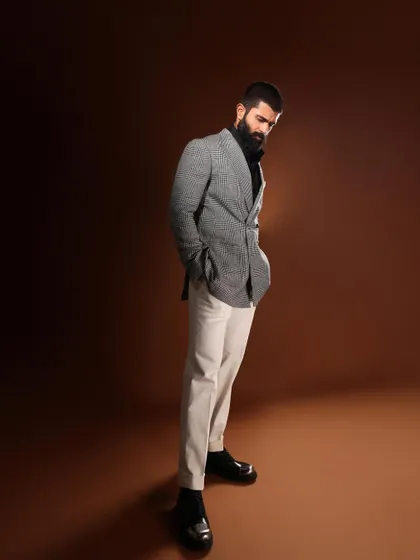 This full-length shot shows the complete outfit for Vijay Deverakonda, from the statement jacket to the sleek black boots, creating a cohesive and stylish ensemble.