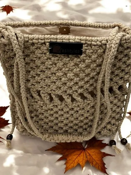 Another shot of the beige potli bag, showing its texture against a backdrop of autumn leaves.