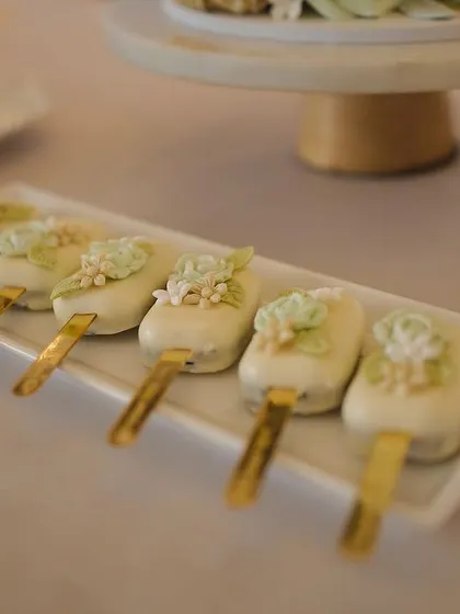 Delicately decorated cake popsicles. These bite-sized treats are perfect for dessert tables and are a popular choice for baptisms, birthdays, and showers.