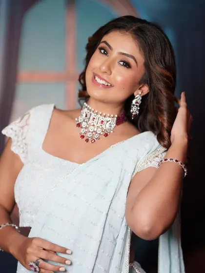 This model is wearing a beautiful AD choker with ruby stones, paired with a delicate, modern saree.
