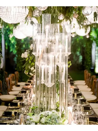 A stunning glass candelabra centerpiece on a long table, demonstrating the grand and dramatic decor elements we can incorporate into our dining setups.