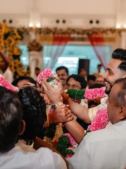 A joyful, candid moment of a couple being lifted up by their families during the wedding ceremony. We capture the energy and fun of the celebration.
