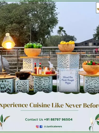 A rustic wood-fired pizza station set up outdoors, with fresh ingredients displayed in woven baskets on charming, patterned stands.
