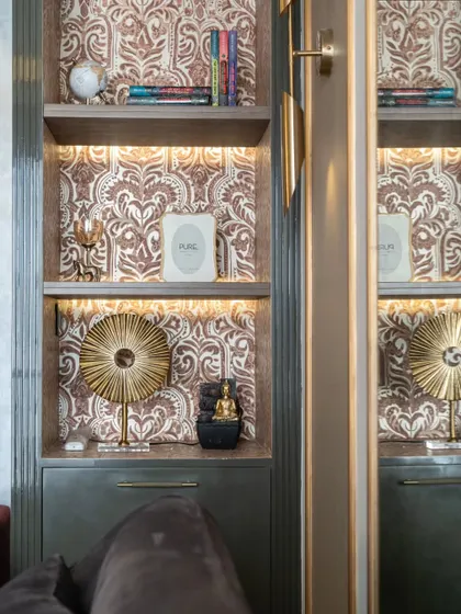 A close-up of the curated items within the display niche, including a small Buddha statue and a golden decorative piece. Every detail is thoughtfully placed to create a harmonious composition.