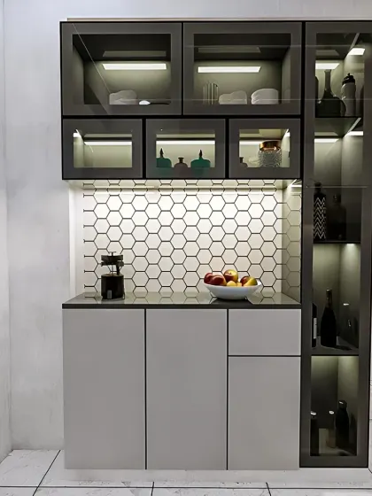 A modern bar and crockery unit with a striking hexagonal tile backsplash. The design features glass-front cabinets with interior lighting and a dedicated tall cabinet for bottle storage.