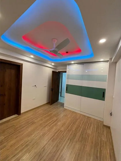 This bedroom features a sliding wardrobe and a false ceiling with colorful cove lighting. This is a great way to add personality and a modern vibe to a teenager's or kid's room.
