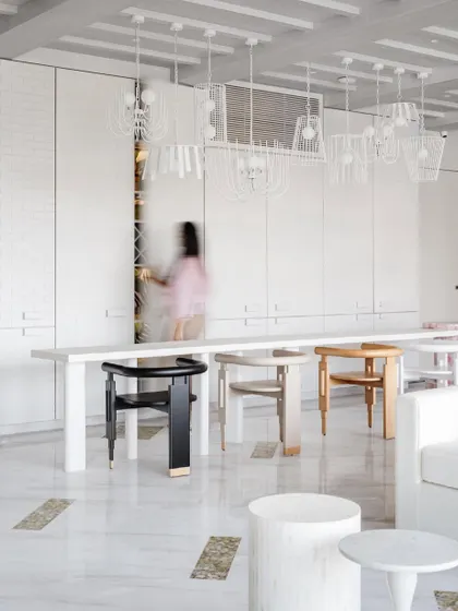 The prohibition-era-esque bar in House No. 7 is blended seamlessly into the wall. The mismatched chairs at the long dining table add an eclectic, collected feel.