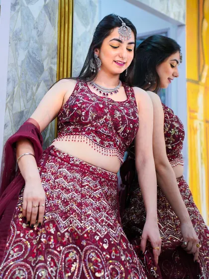 A playful pose in the maroon lehenga, showing how the outfit moves. The reflection in the mirror adds a nice touch to the shot.