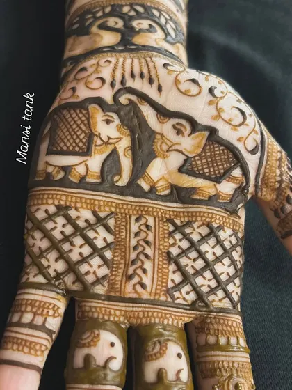 A close up of the palm featuring a pair of elephants. The fingers have small, matching elephant designs, creating a cohesive and charming theme.