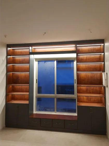 The library nook at night, with integrated LED strip lighting illuminating the bookshelves. This not only highlights the book collection but also creates a warm and inviting ambiance for evening reading.