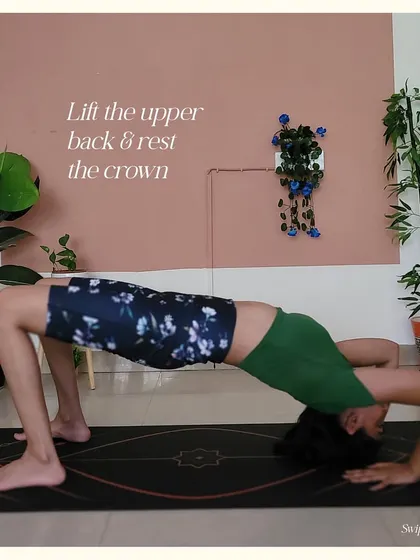Step 4 for Upward Bow Pose: Press into your hands to lift your upper back and rest the crown of your head on the mat.