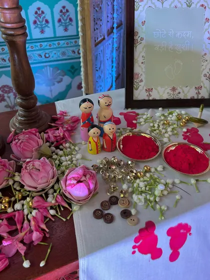 A closer view of the beautifully arranged welcome table, with hand-painted wooden dolls and traditional elements to honor the family.