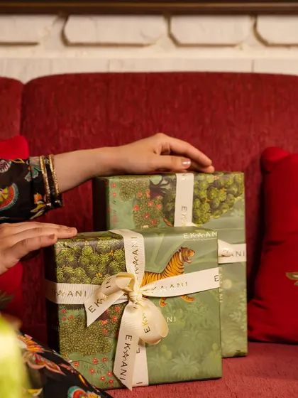 Gift boxes from the Tales of Tropic collection, wrapped and ready to be shared. The lush green patterns and elegant ribbons promise a gift that is both beautiful on the outside and thoughtfully curated on the inside.