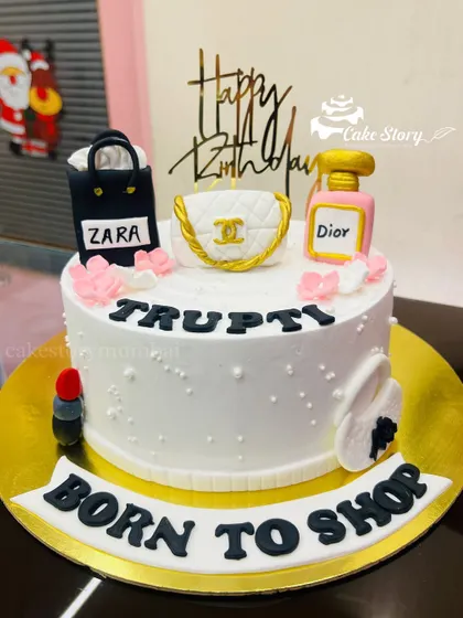 A stylish cake for someone who loves fashion. It features edible toppers of a Zara bag, a Chanel purse, and Dior perfume.