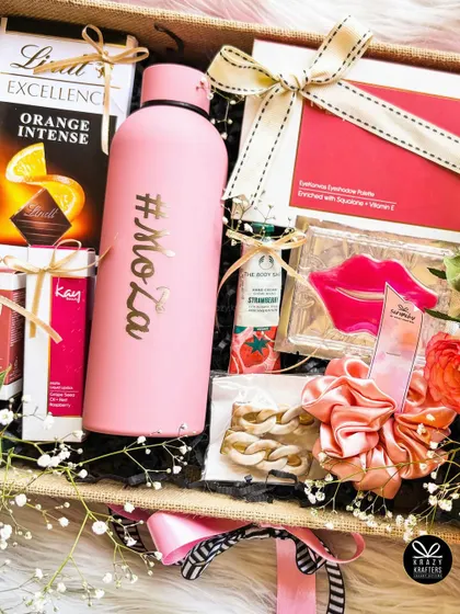 This vibrant birthday hamper combines pink and yellow hues, with a personalized sipper, Lindt orange chocolate, and other pampering items.