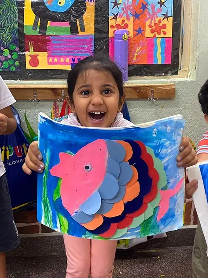 The expressions say it all. These little artists are thrilled with their 3D paper fish, a fun craft that develops fine motor and cognitive skills.
