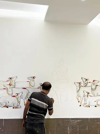 This image shows the beginning stages of a large-scale Pichwai mural. I am sketching out the composition of Lord Krishna surrounded by his herd of cows, setting the foundation for the detailed artwork.