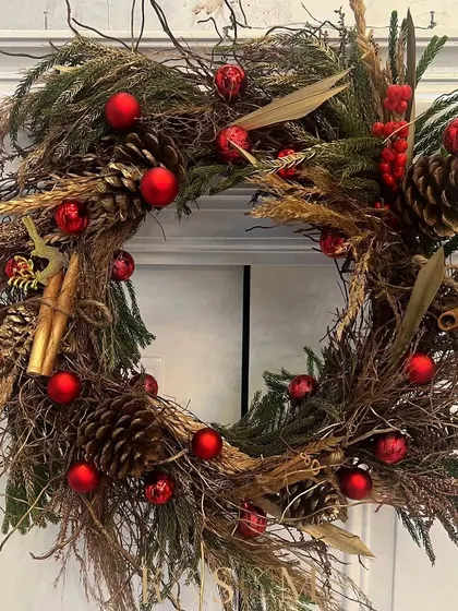 A classic Christmas wreath, dusted with gold and accented with bright red baubles. I wove in cinnamon sticks, pinecones, and wild woody stems for an earthy, fragrant, and festive design.