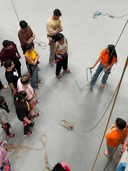 Our instructors conduct a group safety briefing, demonstrating proper harness and rope techniques. We make sure everyone understands the fundamentals before they start climbing.